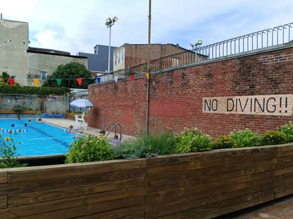 Side view of flower box and pool at Northern Liberties Rec with "No Diving" wall painting